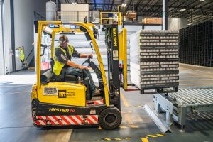 employer qui transporte des palettes sur un chariot élévateur