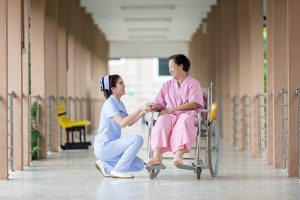 Infirmière qui s'occupe d'une patiente en fauteuil roulant