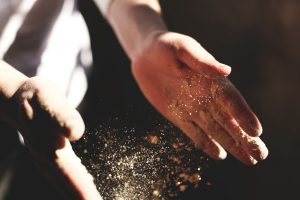 boulanger qui tape ses mains avec de la farine